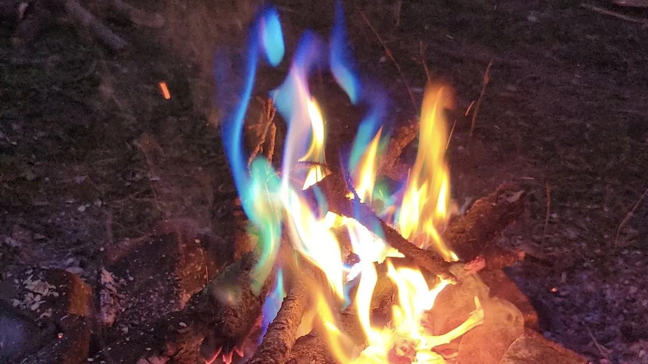 Blue and orange flames rise from a bonfire