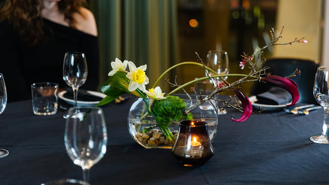 Wine glasses and flowers on a candlelit dinner table