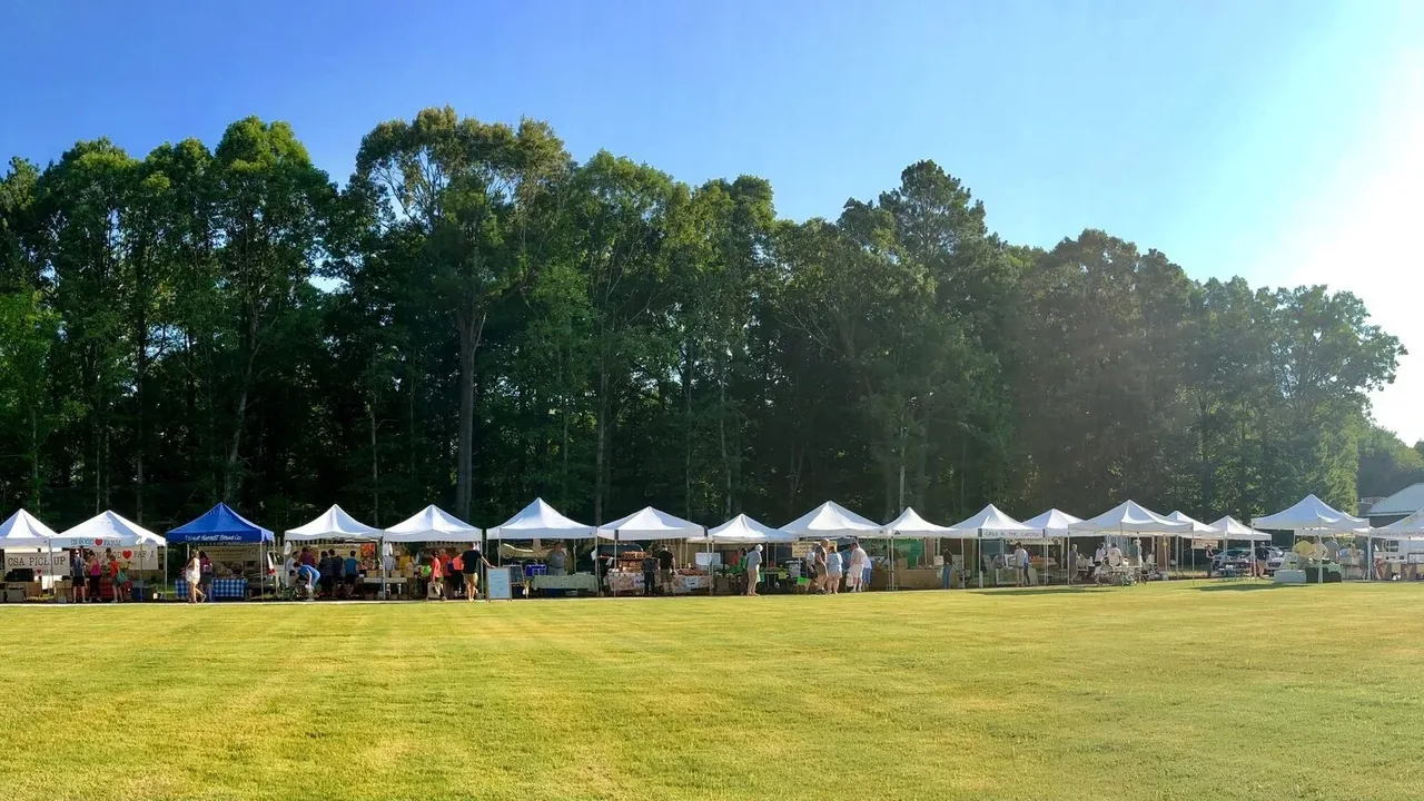 White vendor tents line a sunny field