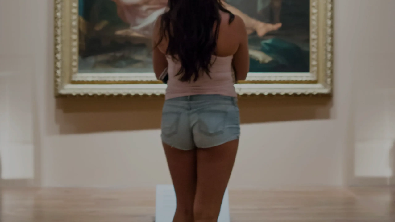 A visitor stands before a framed painting in a gallery