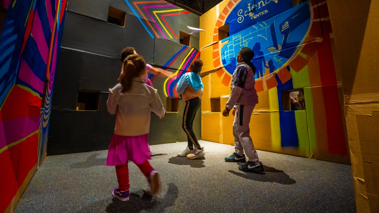 Children explore a brightly painted interactive exhibit wall