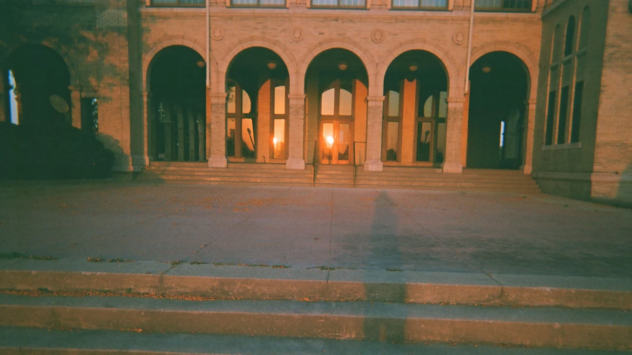 Arched brick entrance of a historic aquarium building lit warmly at dusk.