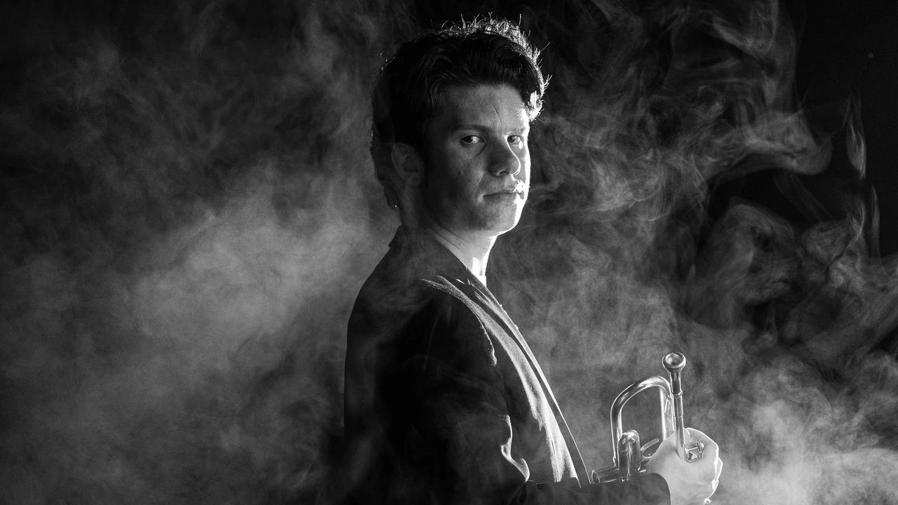 A trumpeter in black and white surrounded by smoke