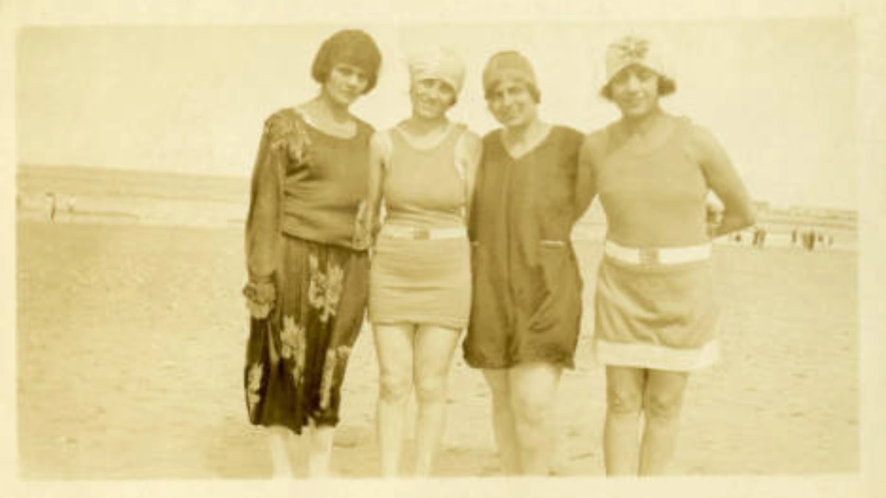 A vintage photo of four women in 1920s dress on a beach