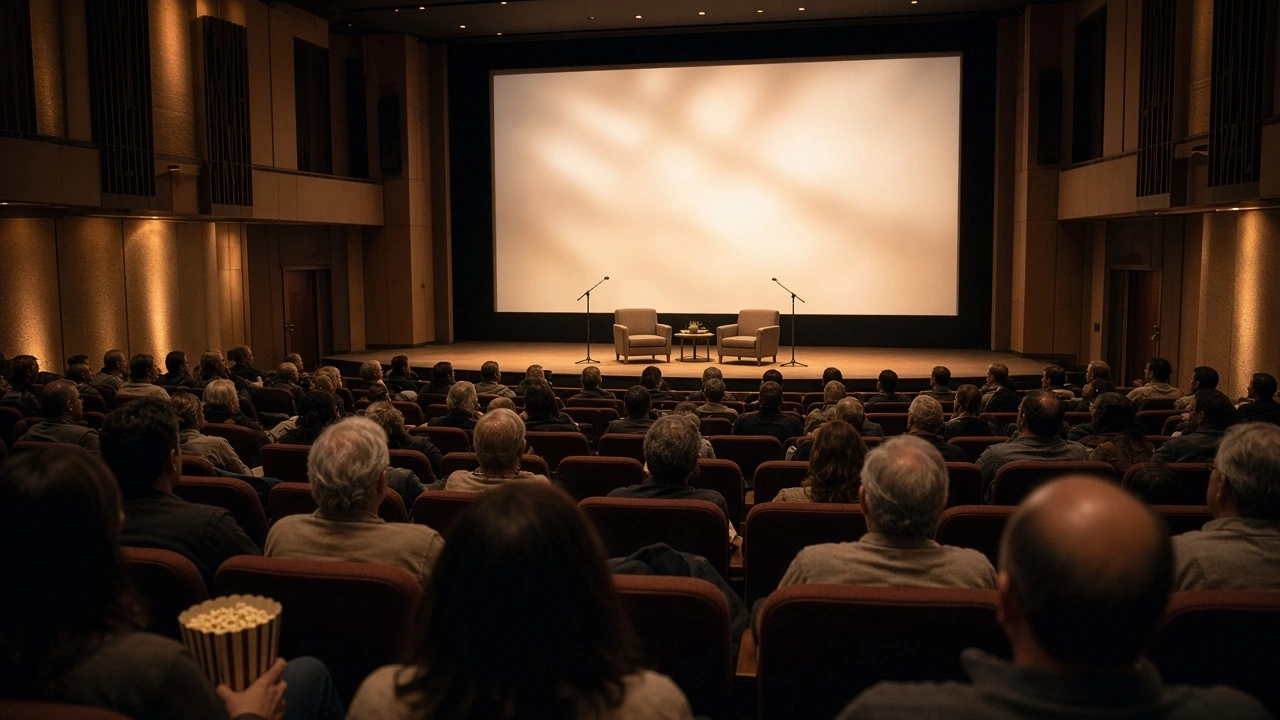 An audience seated in a large theater facing a blank white screen.