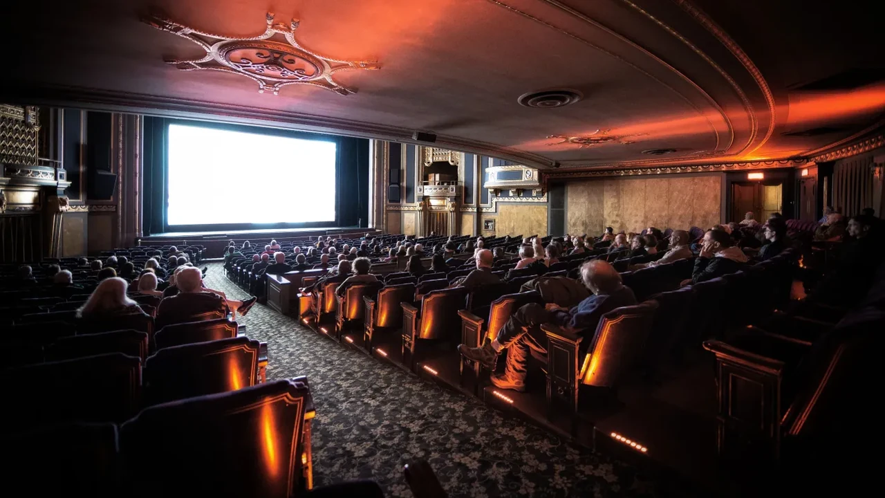An audience watches a film in a classic movie theater