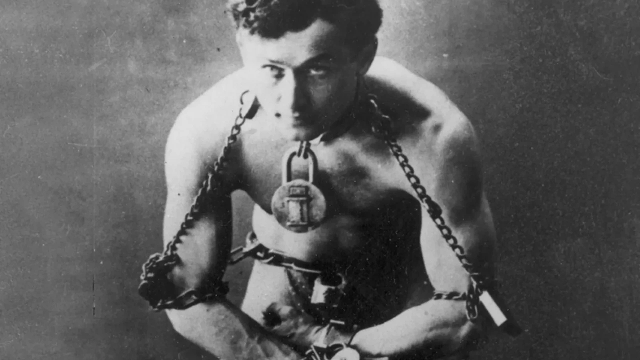 A vintage photo of a shirtless escape artist bound in chains