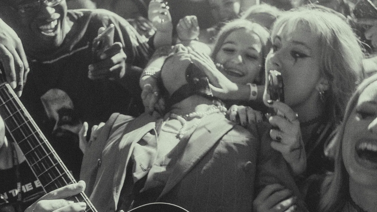 A crowd of fans singing along in black and white
