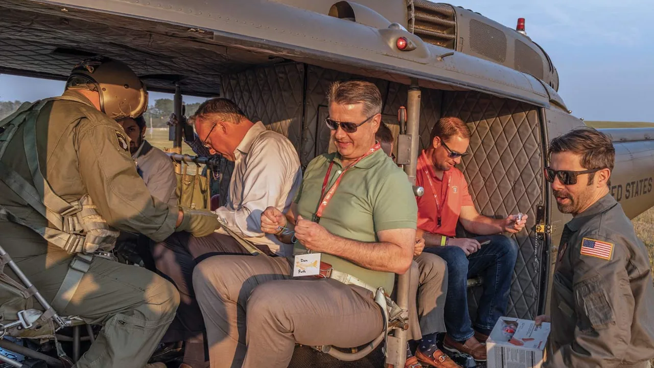 Men in vintage military uniforms sit inside an old vehicle