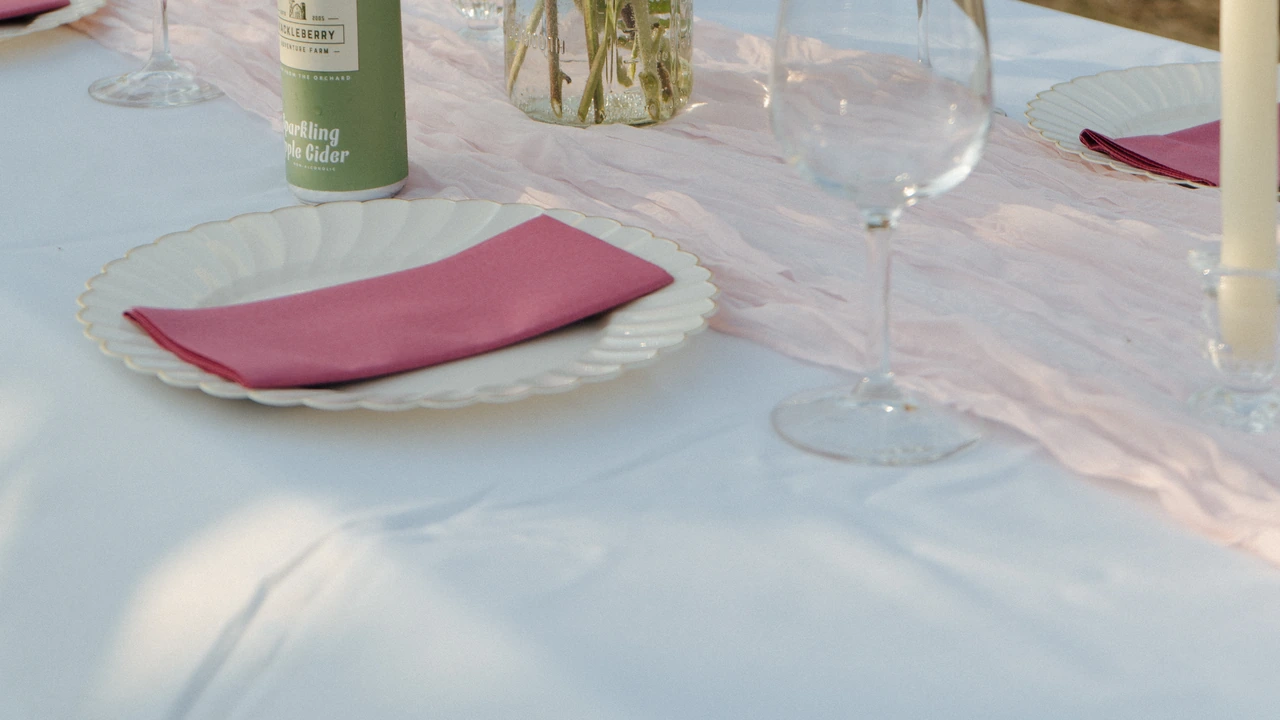 A table set with glassware and folded pink napkins