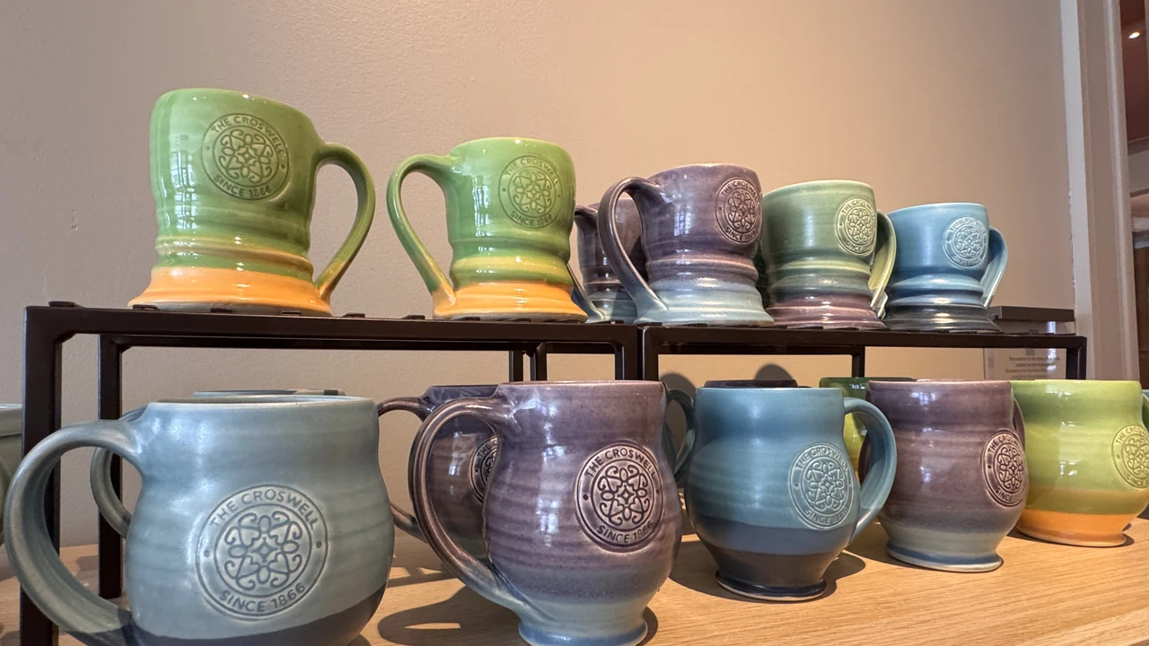 Handmade glazed pottery mugs on a shelf