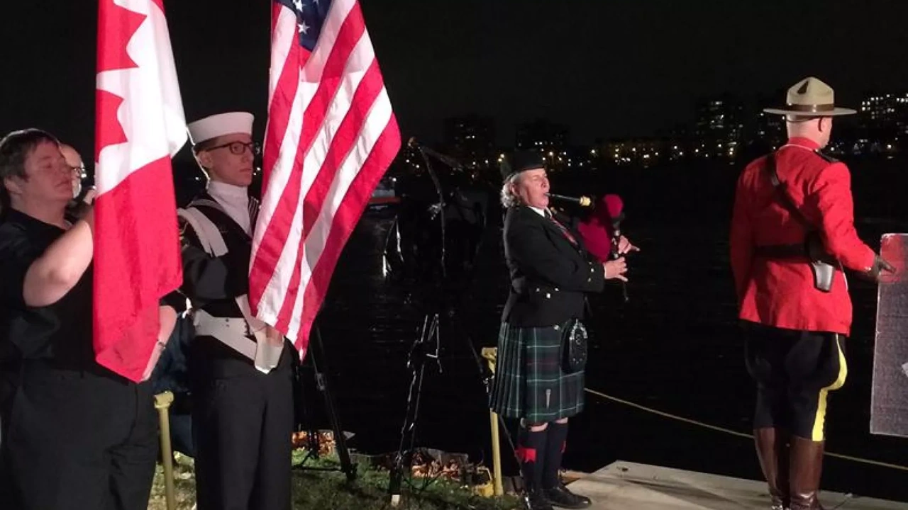 Flag bearers, a bagpiper and a Mountie in red at a night ceremony