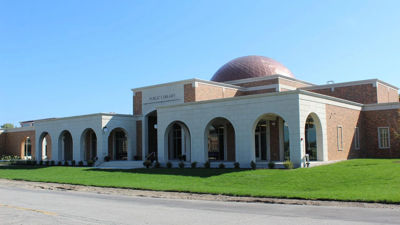 A domed brick building with arched arcades on a green lawn