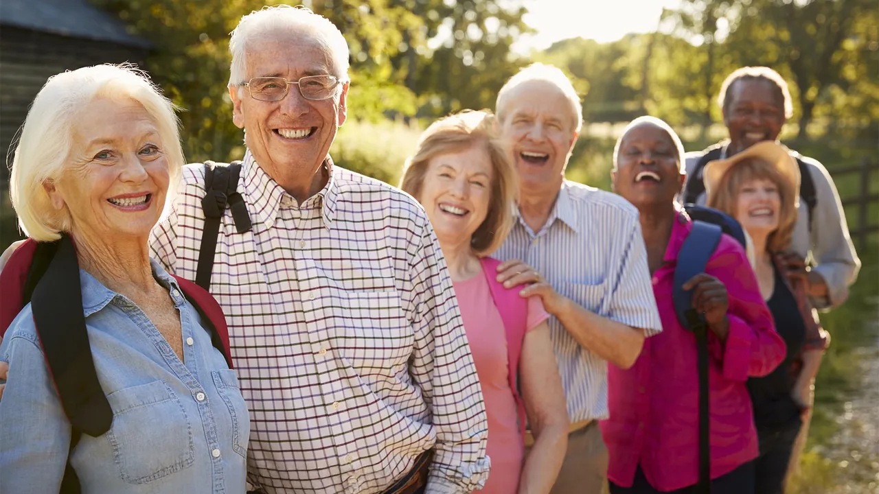 A smiling group of older adults gathered outdoors