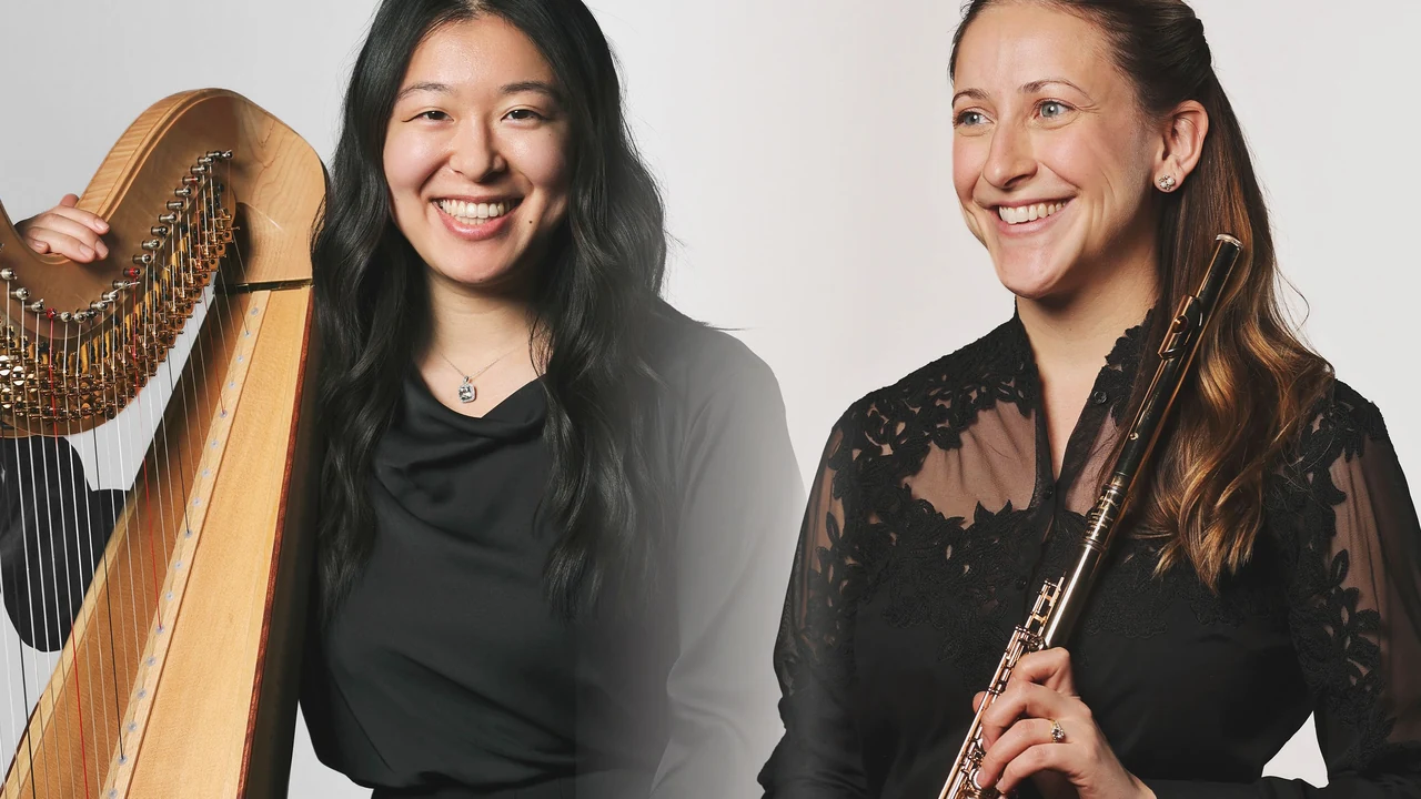 A harpist and a flutist in black dresses smile side by side with their instruments.
