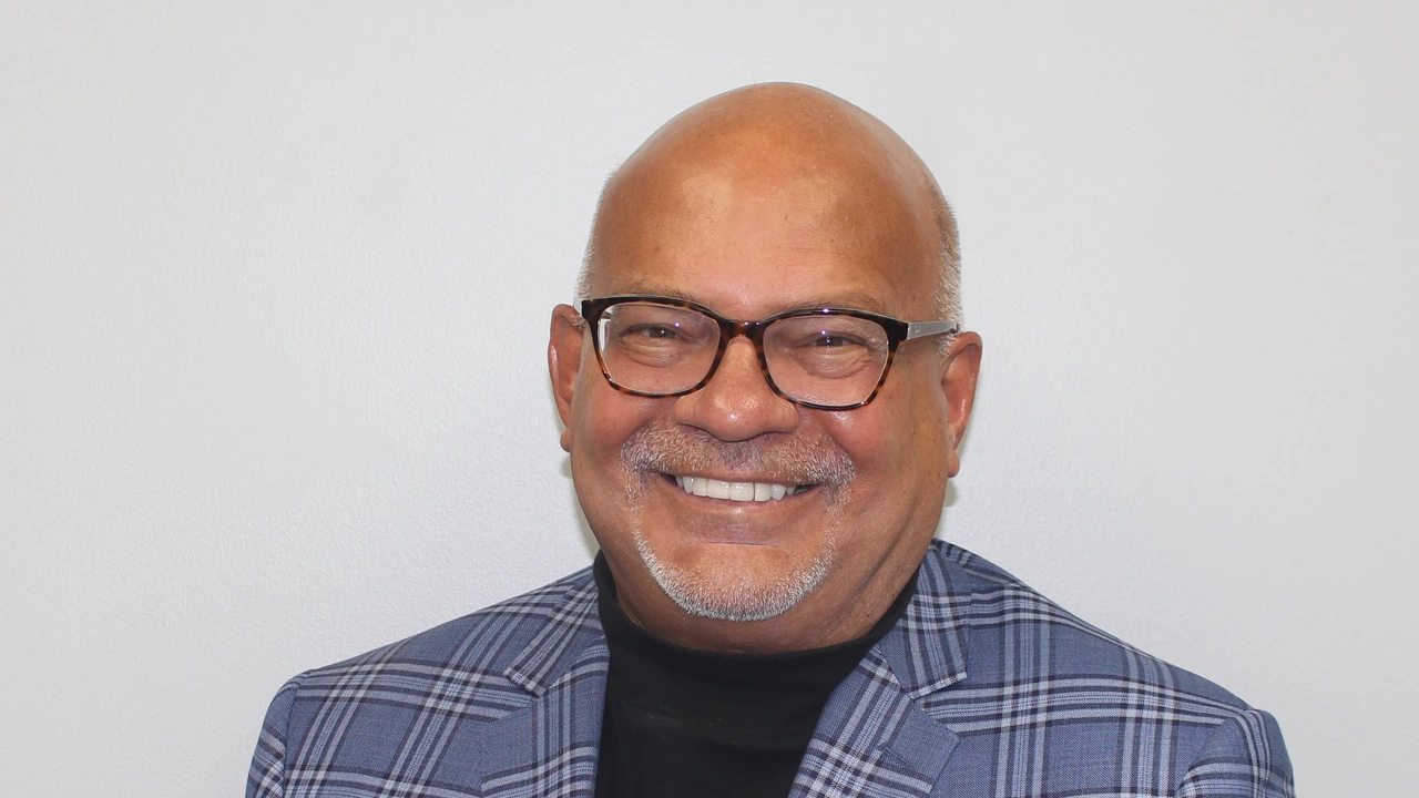 Portrait of a smiling man in glasses and a plaid blazer