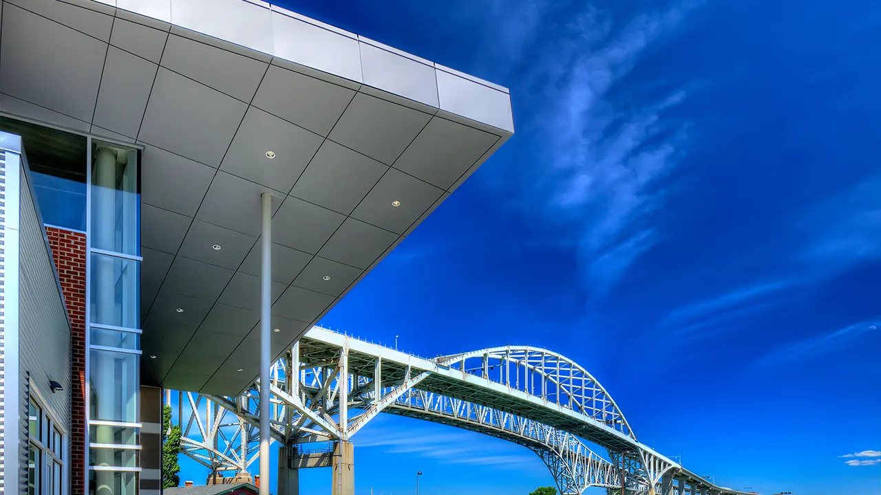 A modern building beside a blue arched bridge