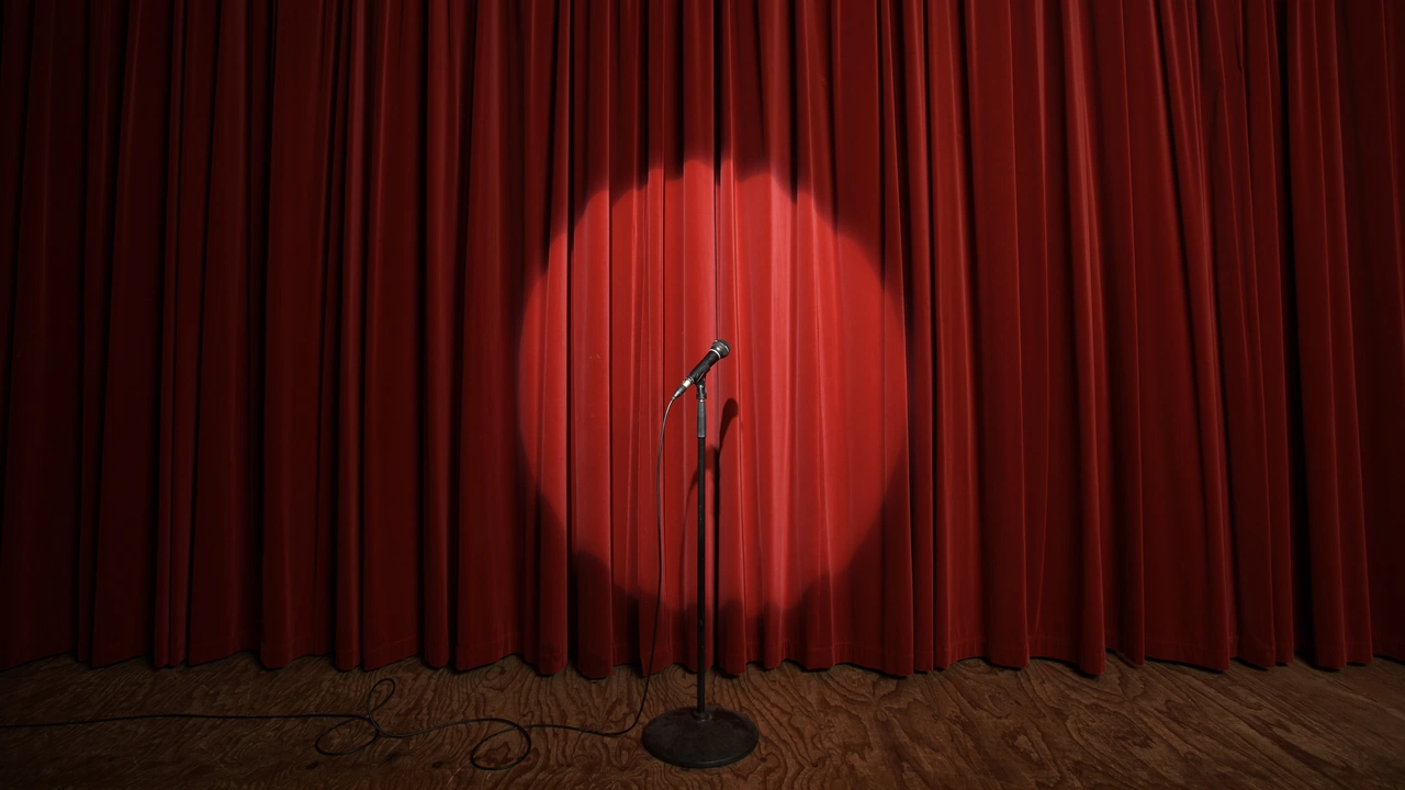 A spotlight on a lone microphone before a red stage curtain