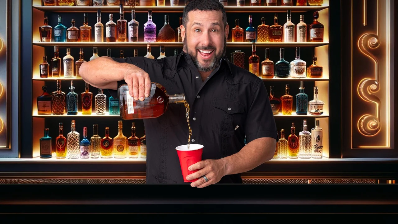 A bartender pours a drink in front of shelves of bottles