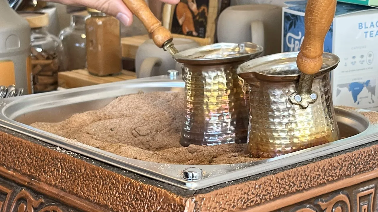 Copper coffee pots set in hot sand