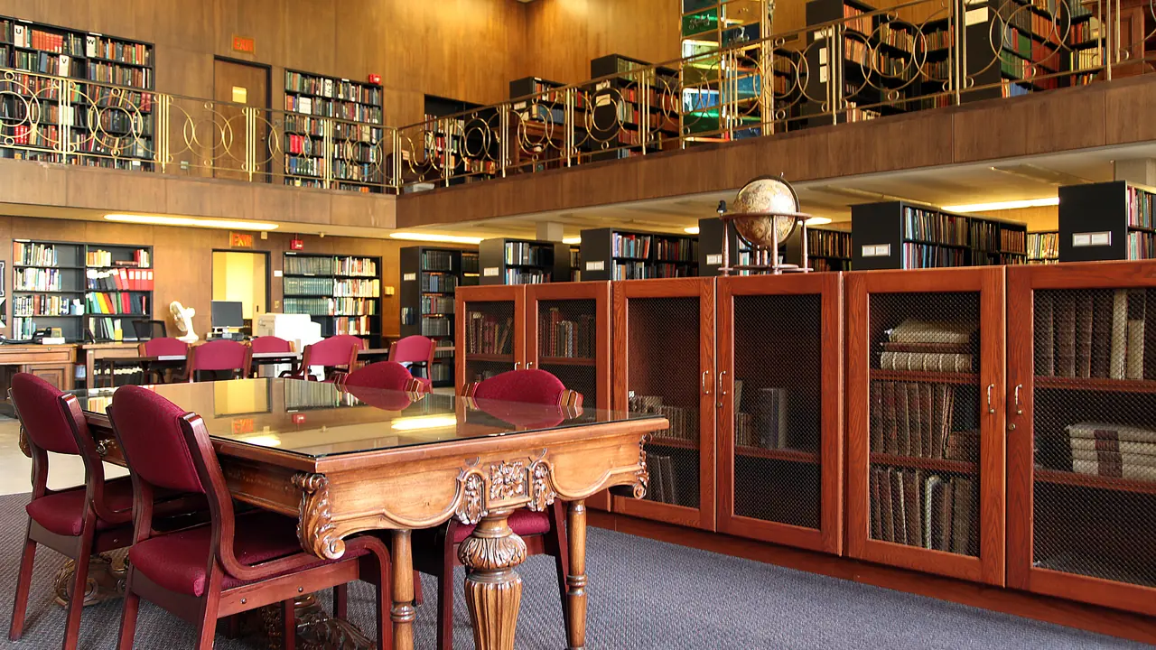 A wood-paneled library reading room with tall bookcases