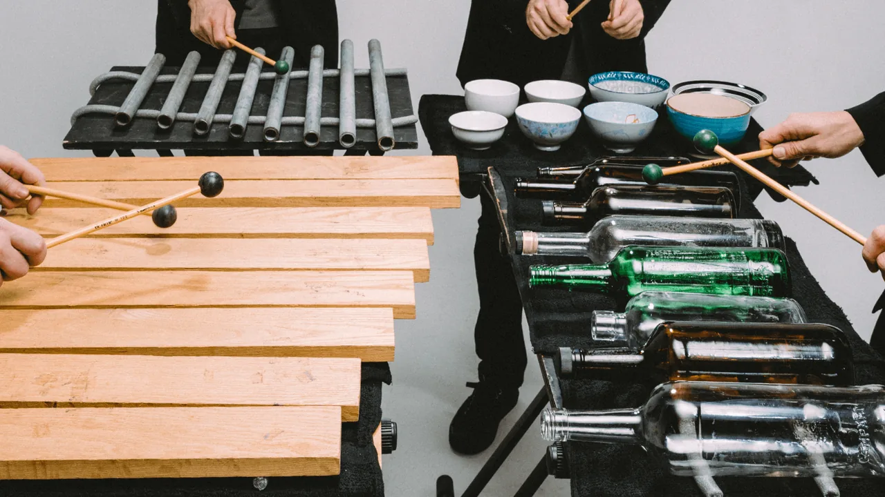 Percussionists strike marimbas and gongs