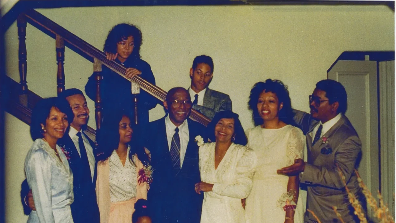 A vintage group photo of men and women in formal dress on a staircase